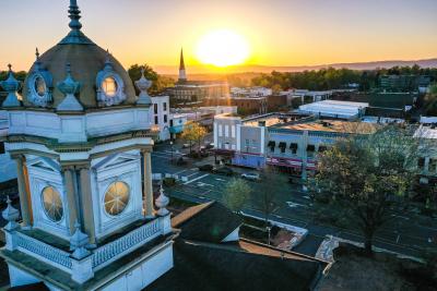 An aerial image of Downtown Morganton at sunset featuring the Historic Courthouse and local shops